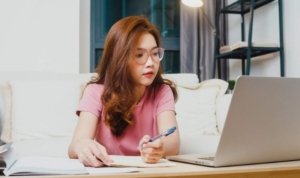 Mahasiswa sedang menggunakan laptop dengan ilustrasi kecerdasan buatan AI